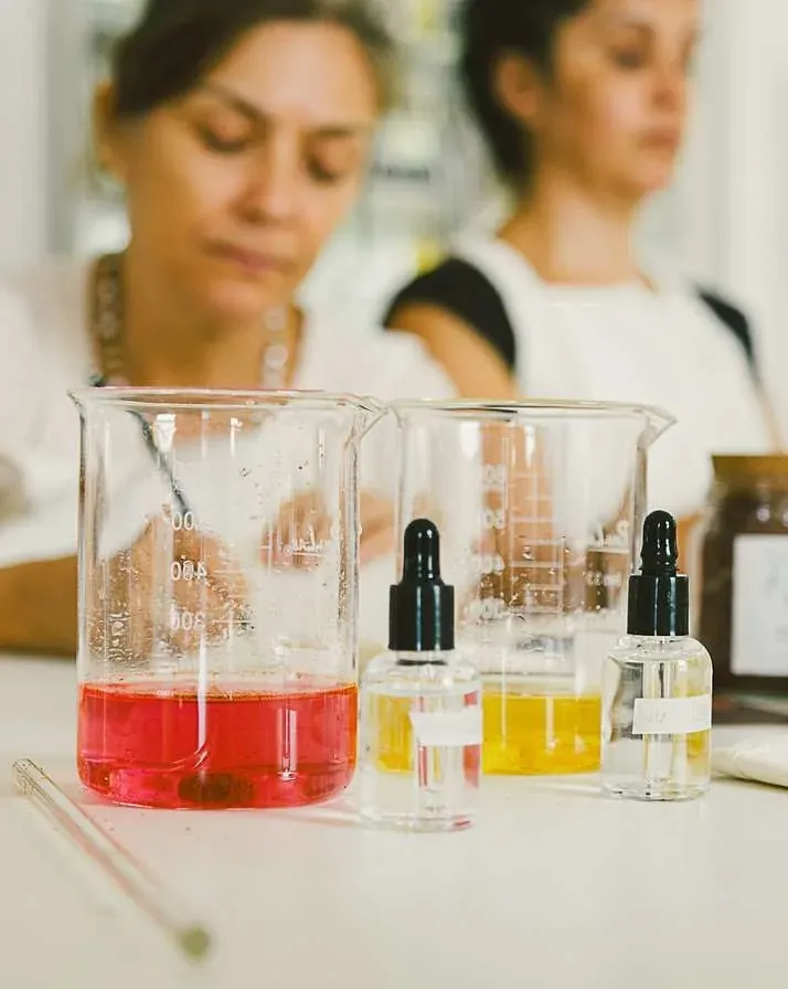 Béqueres com extratos de corante natural rosa e amarelo sobre a bancada