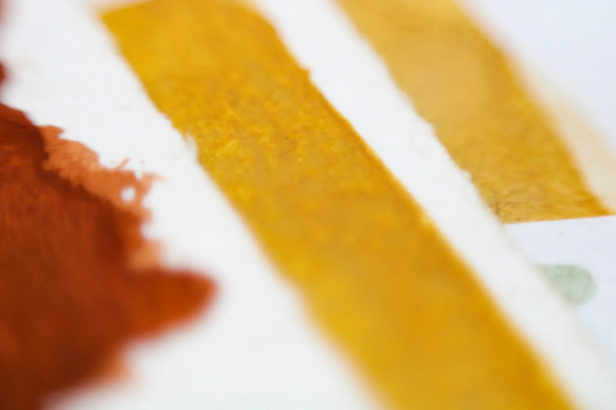 Pinceladas de aquarela em ocre e terracota sobre papel branco