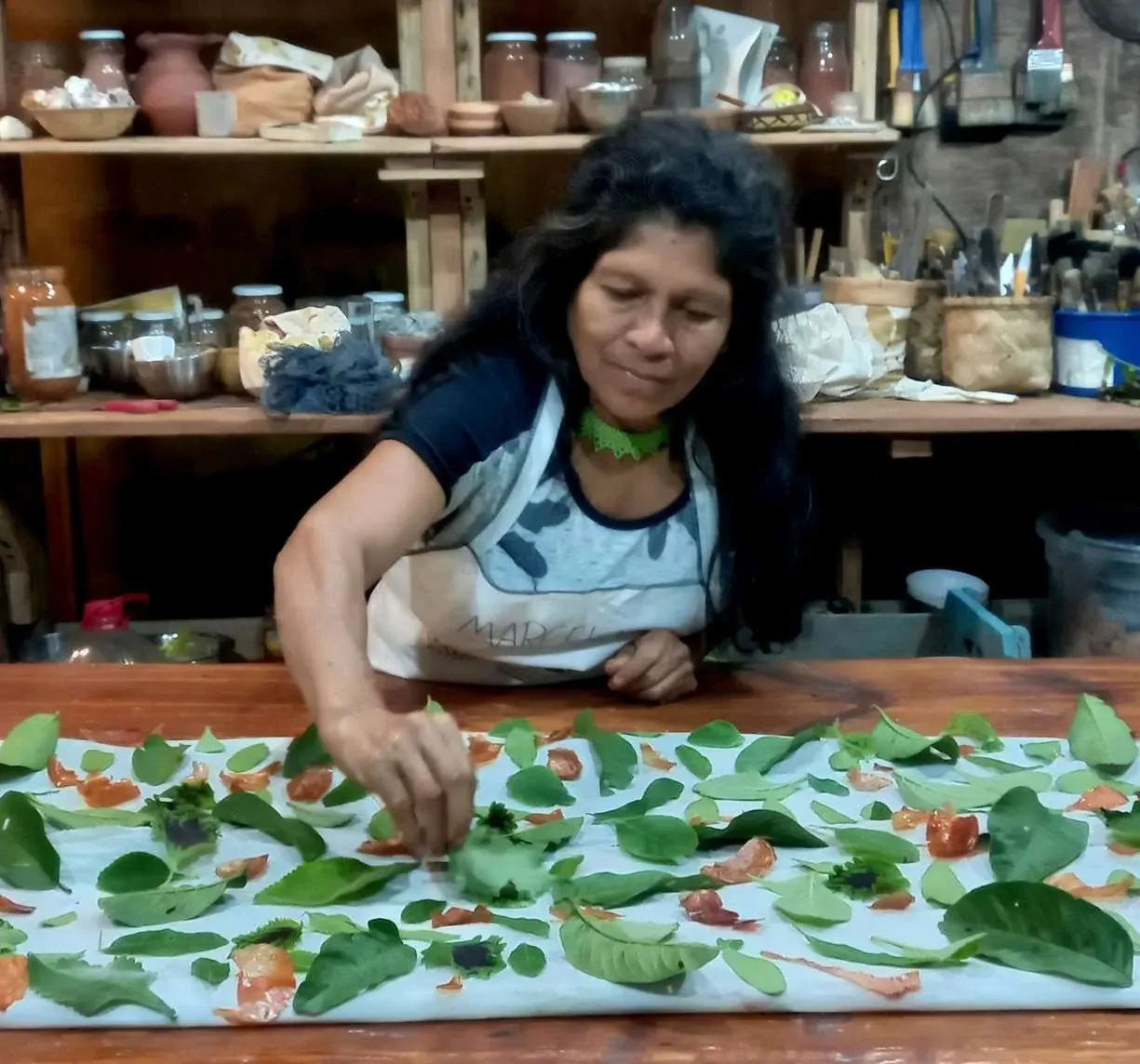 Folhas e flores dispostas sobre tecido branco preparado para impressão botânica