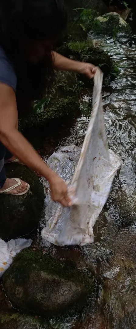 Tecido tingido sendo lavado nas águas do rio